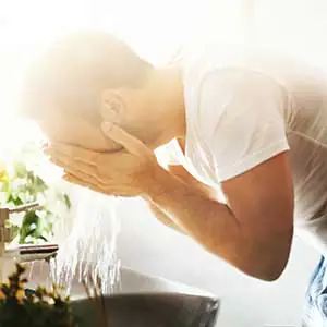 Mann wäscht sich das Gesicht